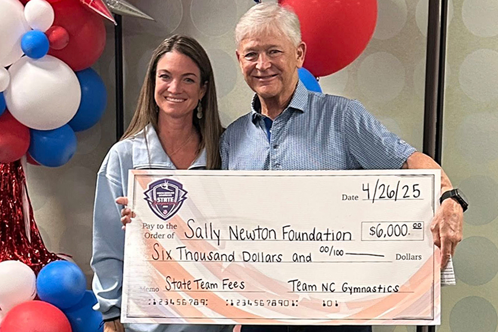 Tom Newton accepts donation from Team NC Gymnastics